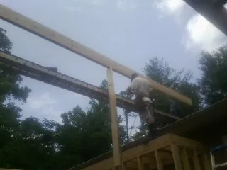 Carpenter setting a ridge beam over a new addition frame — Ice Dam Removal by Roofing Brothers in Shrub Oak
