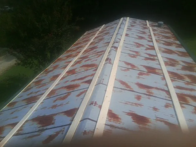 Rusted metal roof panels with new wood purlins before replacement — Storm Damage Roof Repair in Shrub Oak by Roofing Brothers