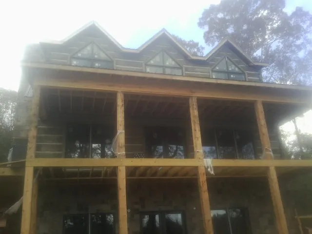 Dormers and porch framing on a large log home under construction — Roof Coating work by our crew in Shrub Oak