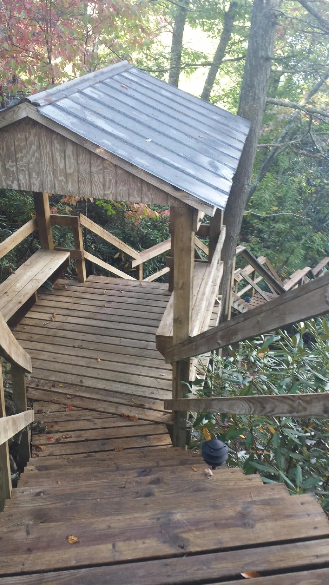 Metal roofed shelter over wooden steps on a wooded walkway — Skylight Repair & Installation work by our crew in Shrub Oak